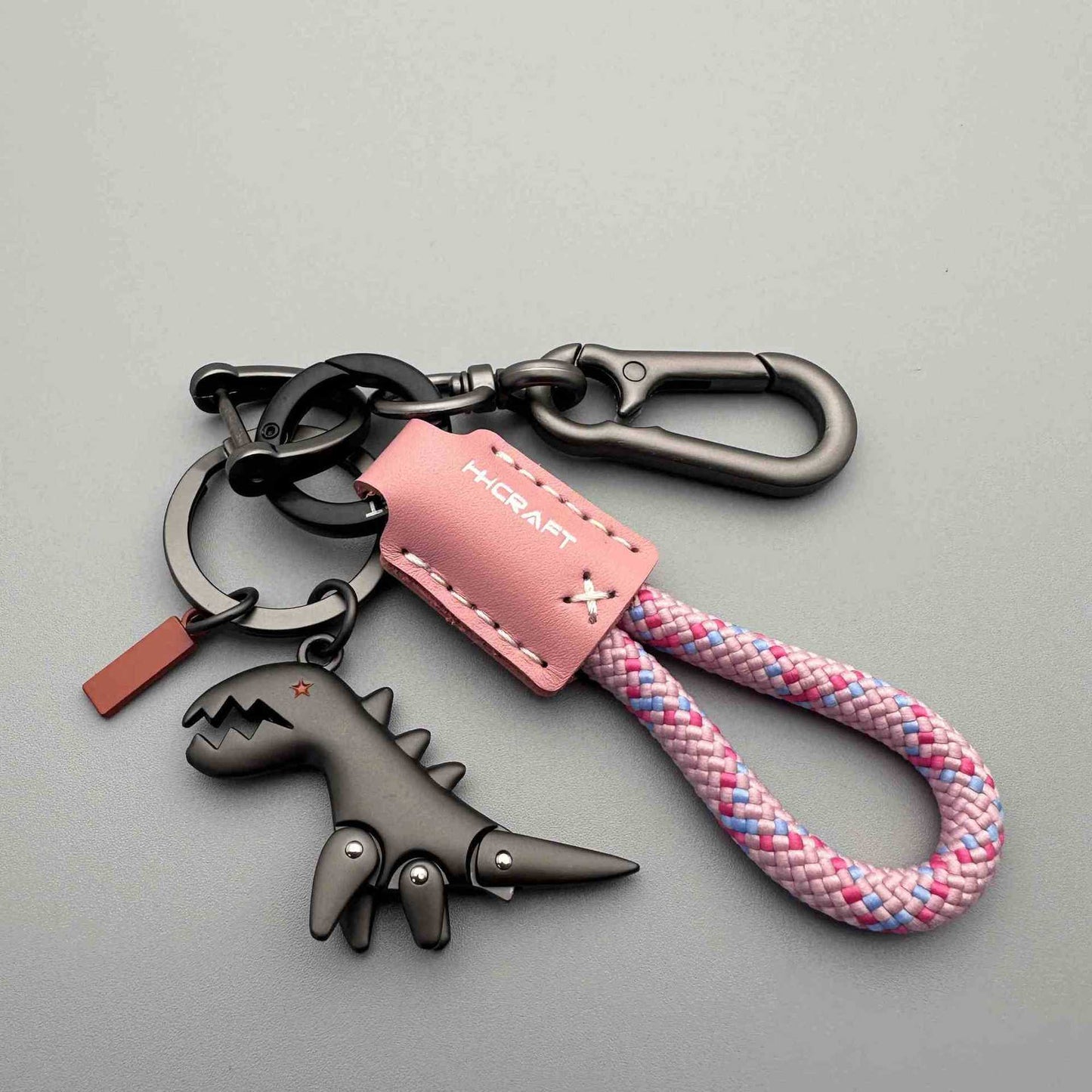 Breloque dinosaure en alliage d'aluminium associée à un bracelet tissé à la main